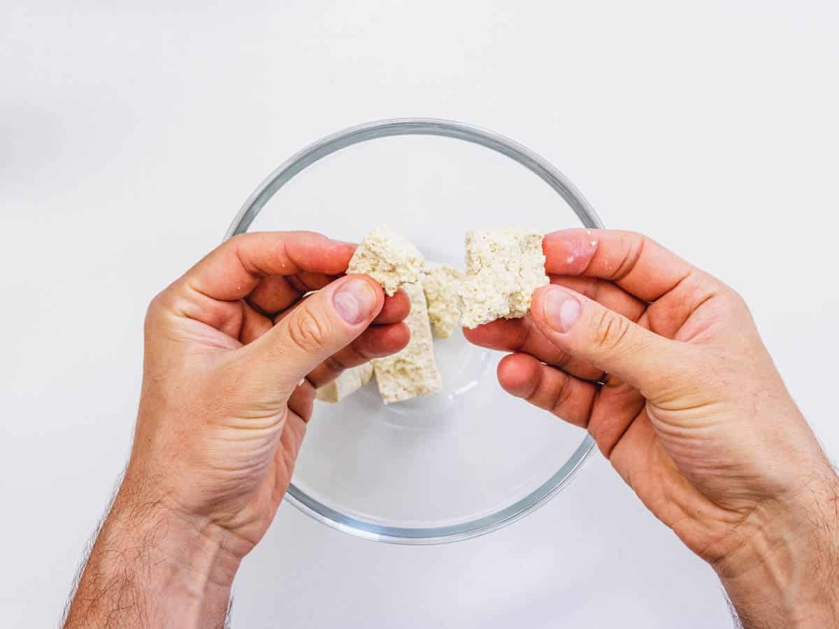tearing the tofu apart with hands