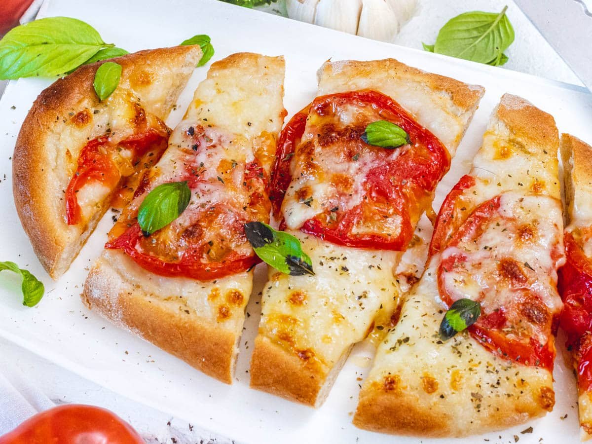 Flatbread pizza with tomatoes and melted cheese