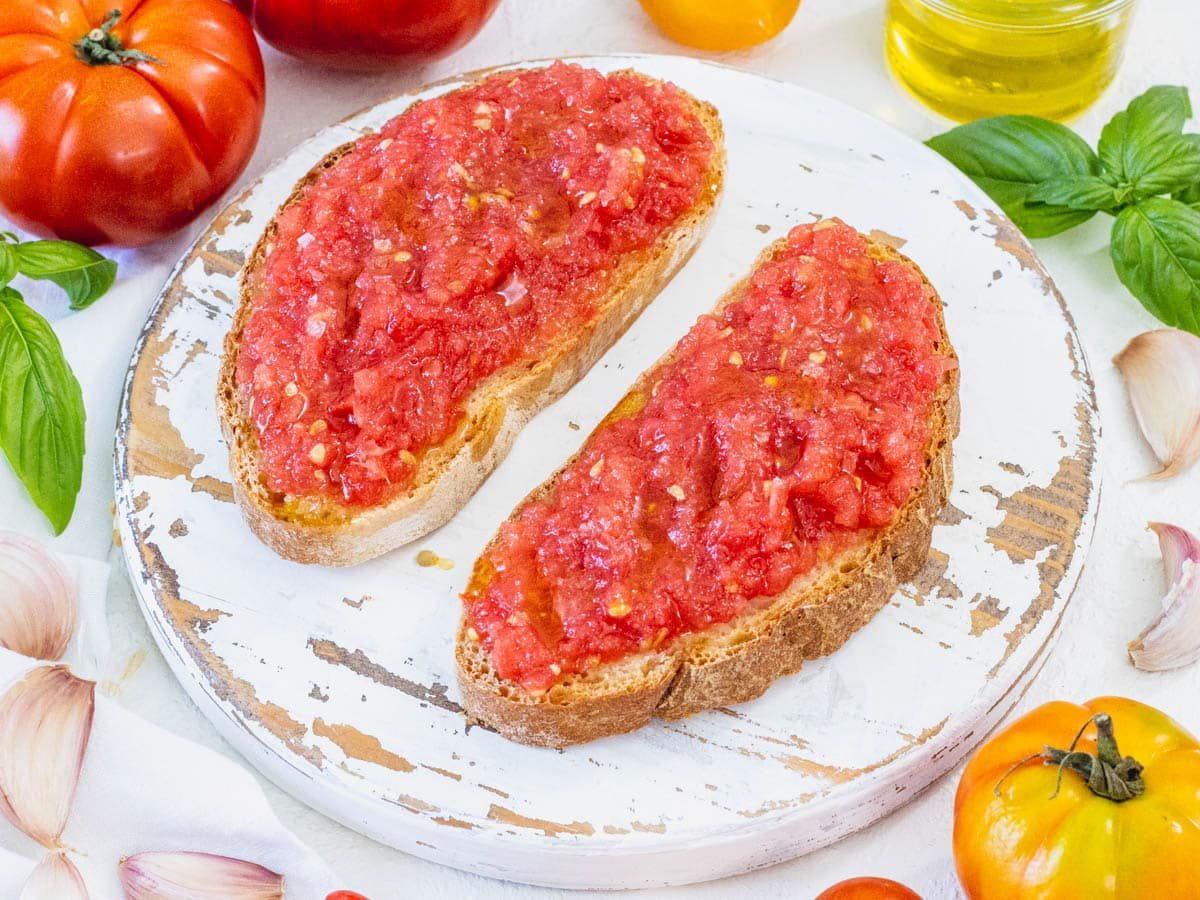 Pan con tomate with heirloom tomatoes on a white platter