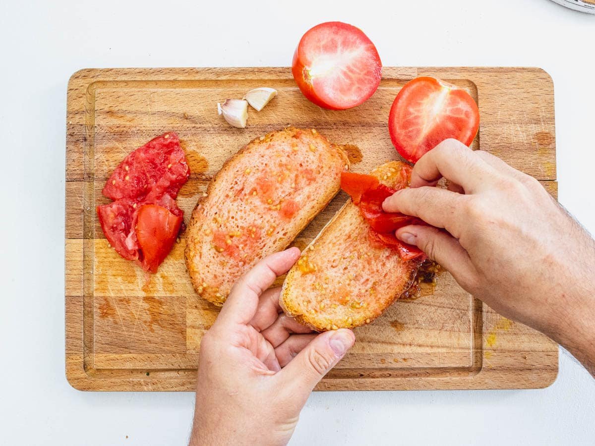 rubbing ripe tomatoes on bread slices