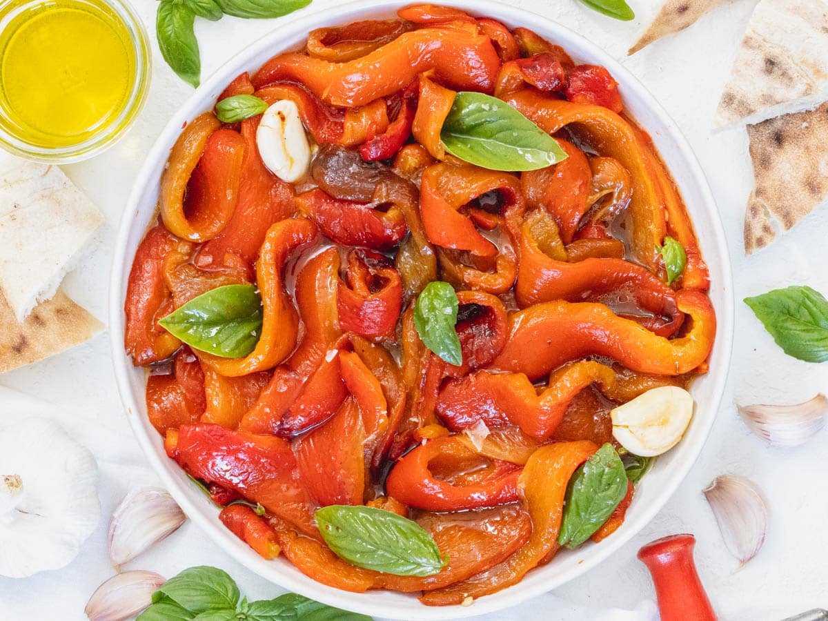 Roasted bell peppers in a bowl with basil