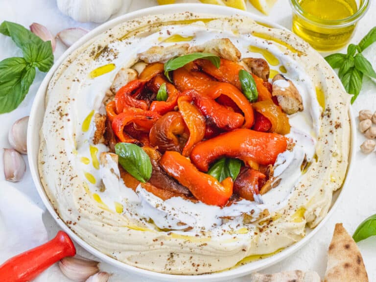 Roasted bell peppers on a bed of hummus