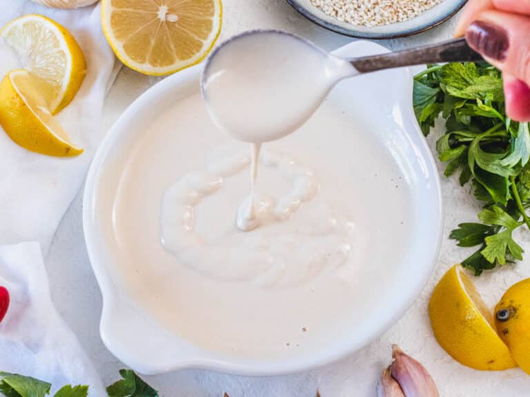 Tahini sauce with a silver spoon