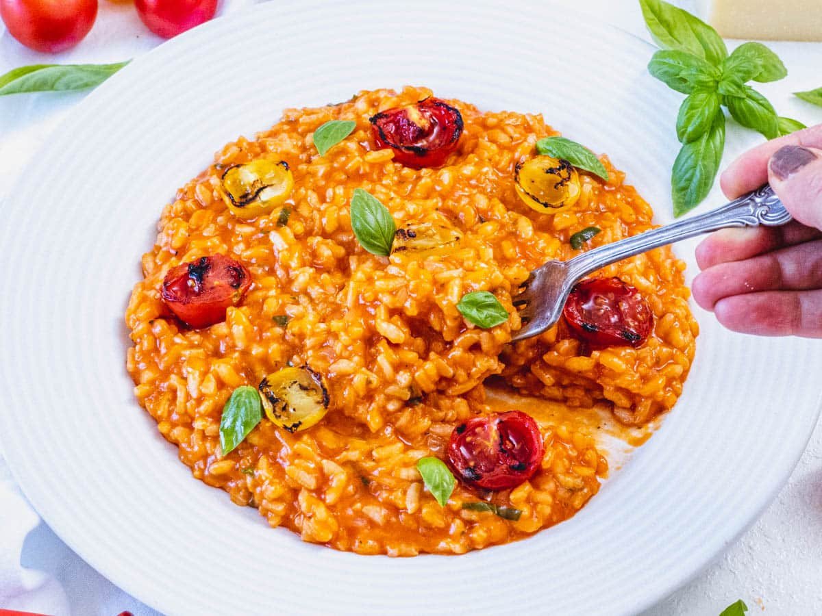 Tomato risotto with hand and fork