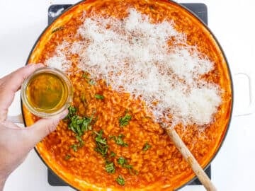 parmesan cheese and oil added to tomato risotto