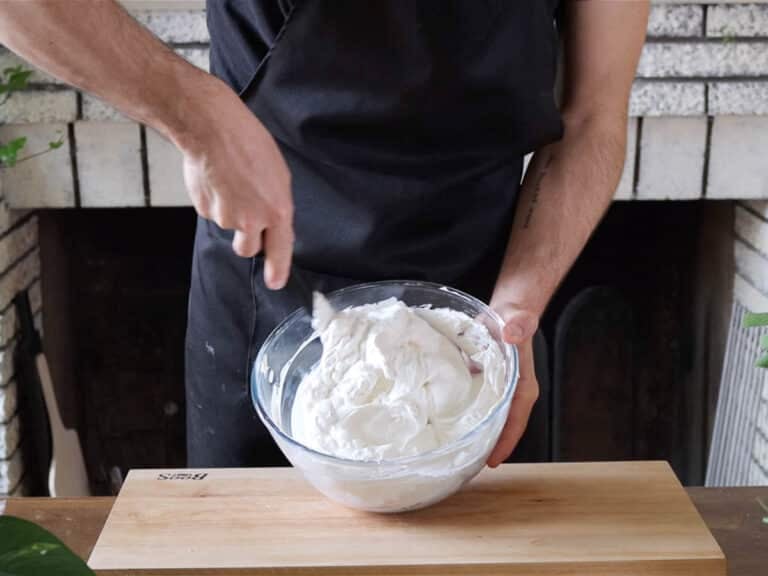 Hands mixing the cream cheese topping