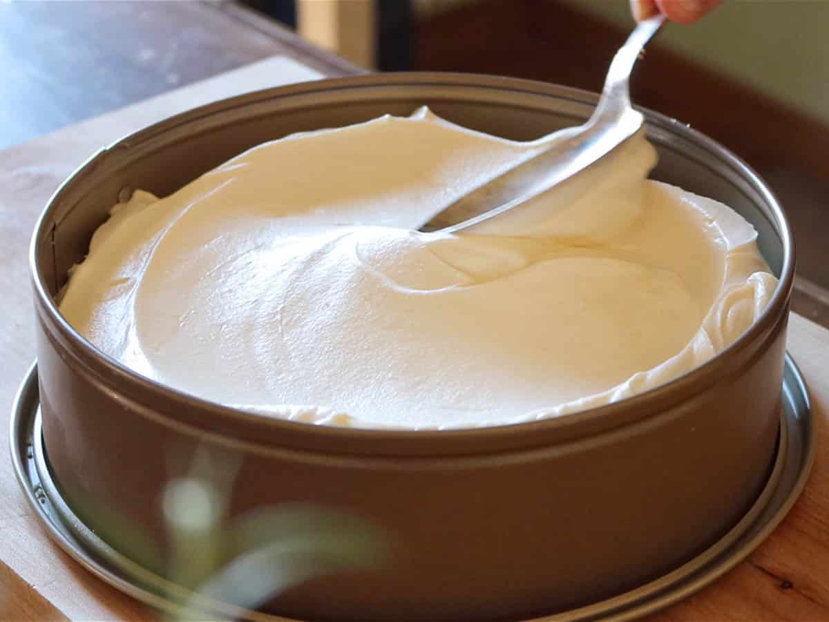 Spoon and cream cheese topping in a cake pan