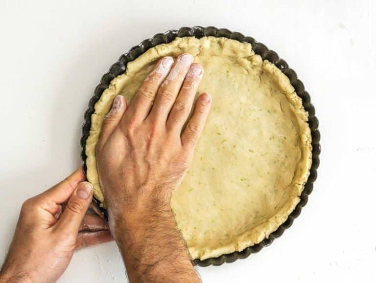 fruit tart pie crust and hands flattening crust