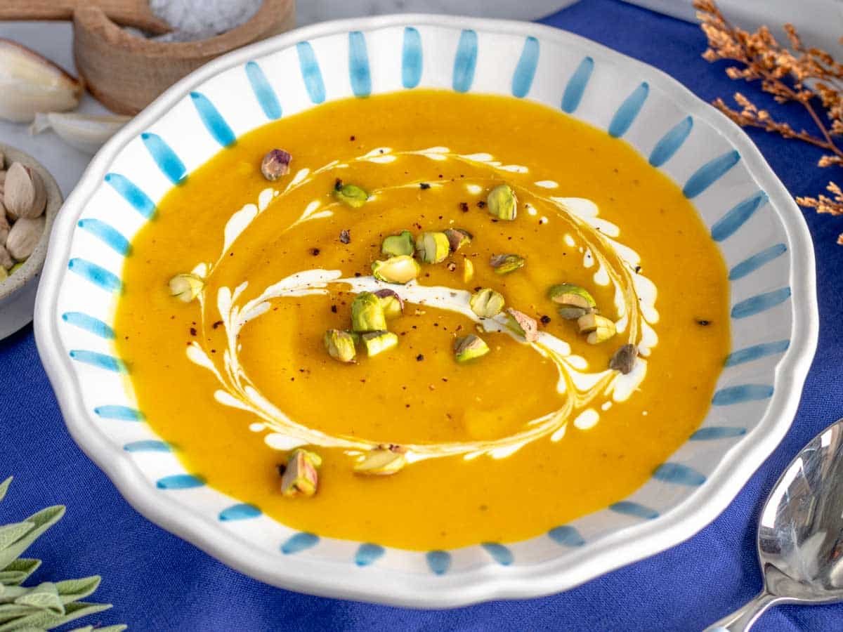 Butternut squash soup topped with nuts and cream.