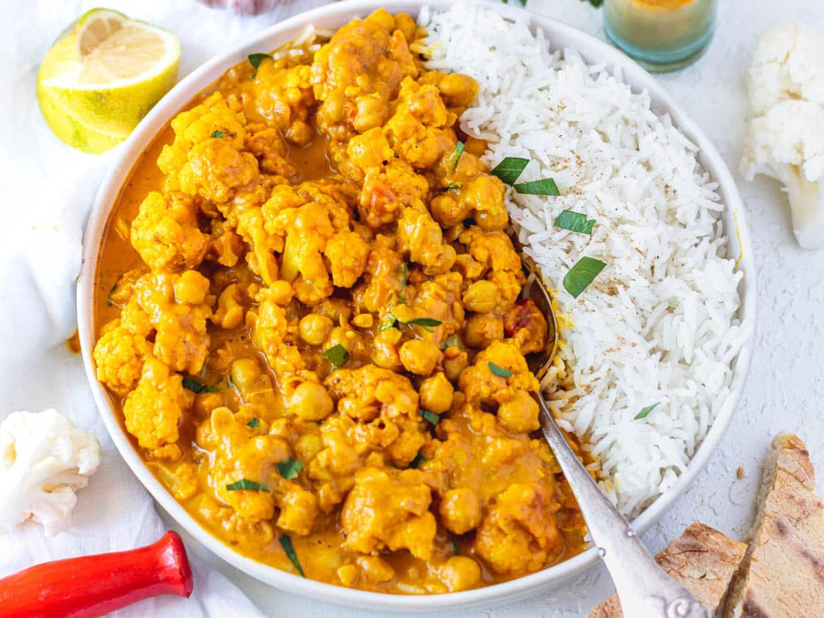 Cauliflower Curry with a lemon wedge and spoon
