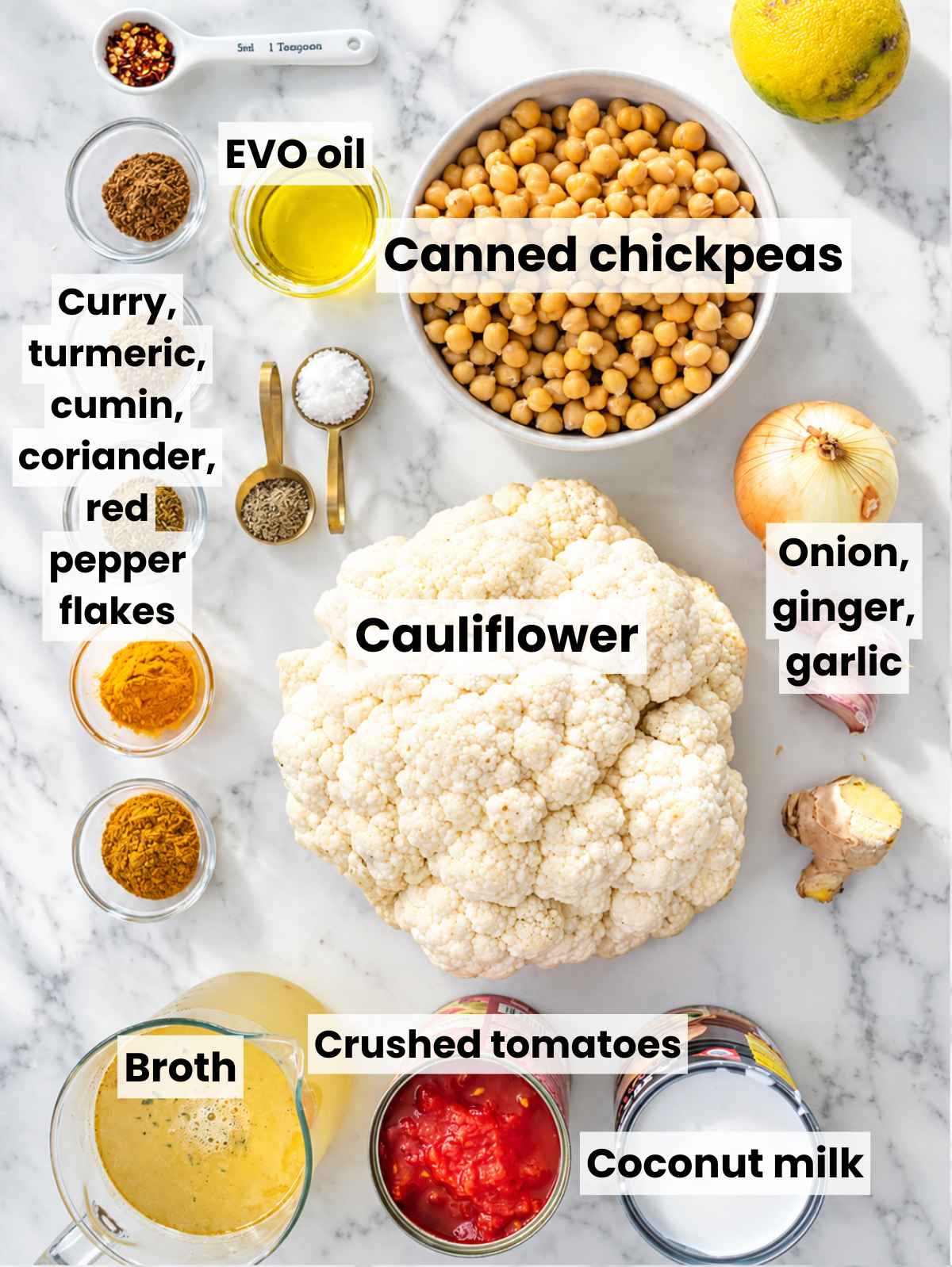 Cauliflower curry ingredients arranged on white marble in bright natural light