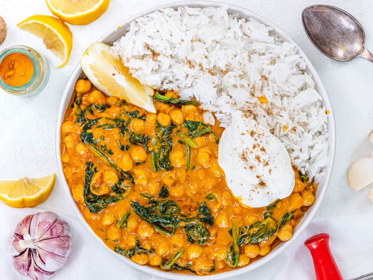 creamy bowl of chickpea curry with spinach and basmati rice