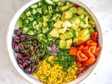 veggies, olives and avocado chopped in a white bowl