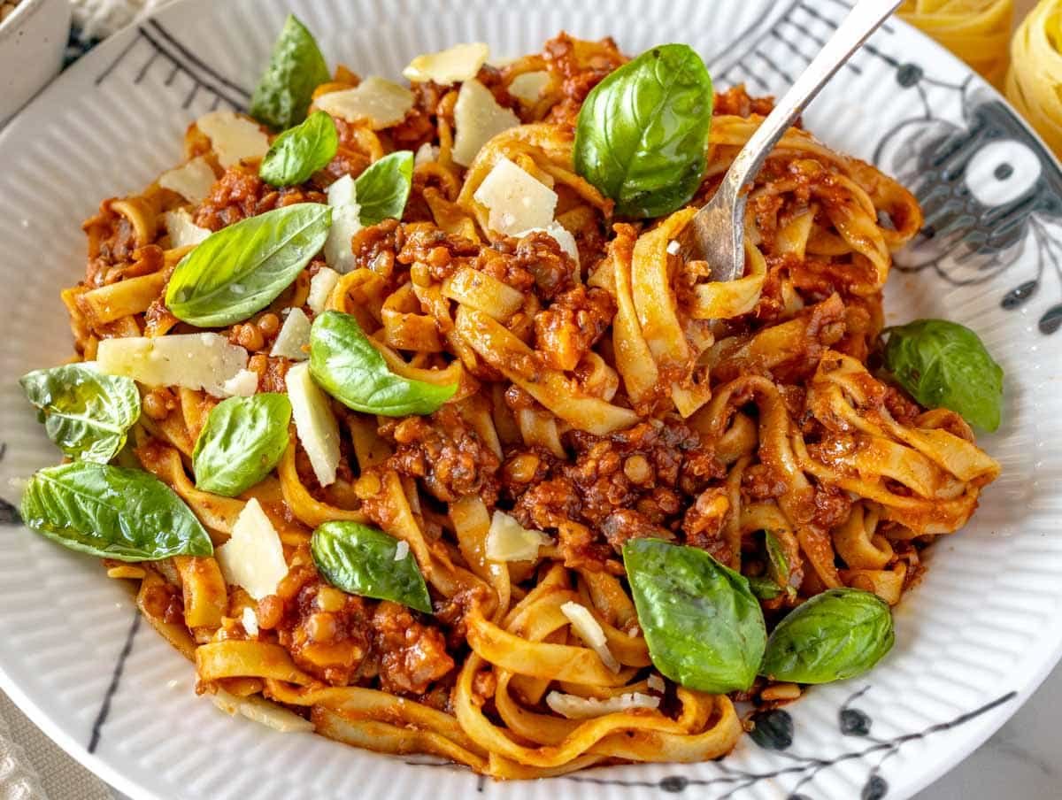 Lentil Bolognese with fresh basil and a silver fork