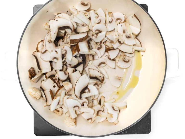 sliced mushrooms on a pan with oil and salt