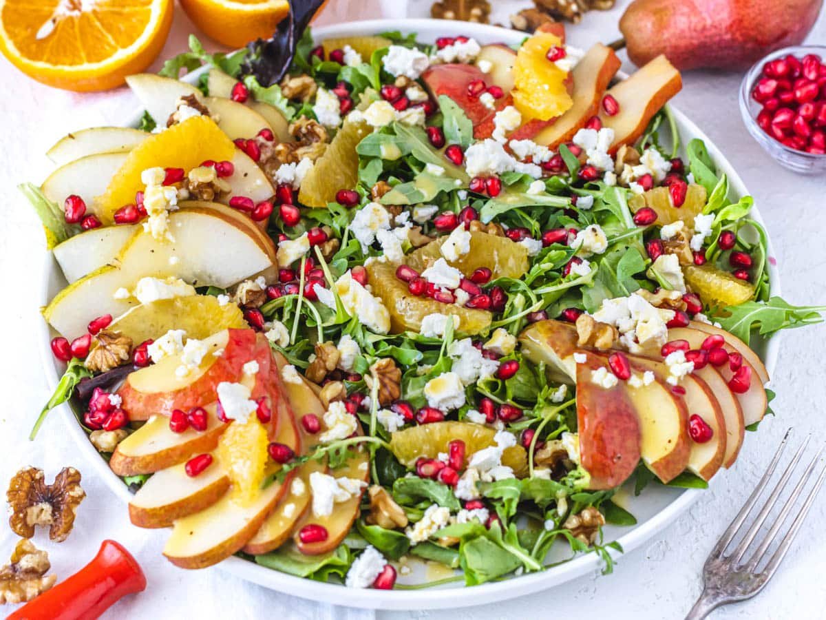 Pear salad on a plate with pomegranate seeds