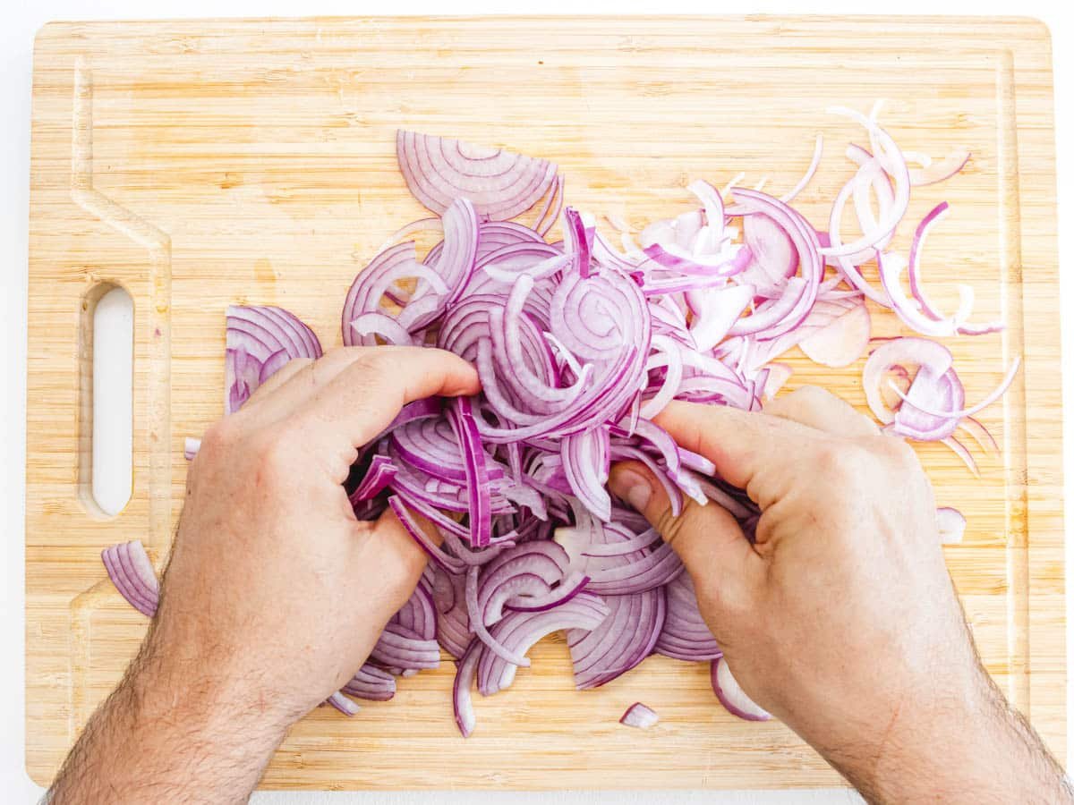 hands massaging red onions 