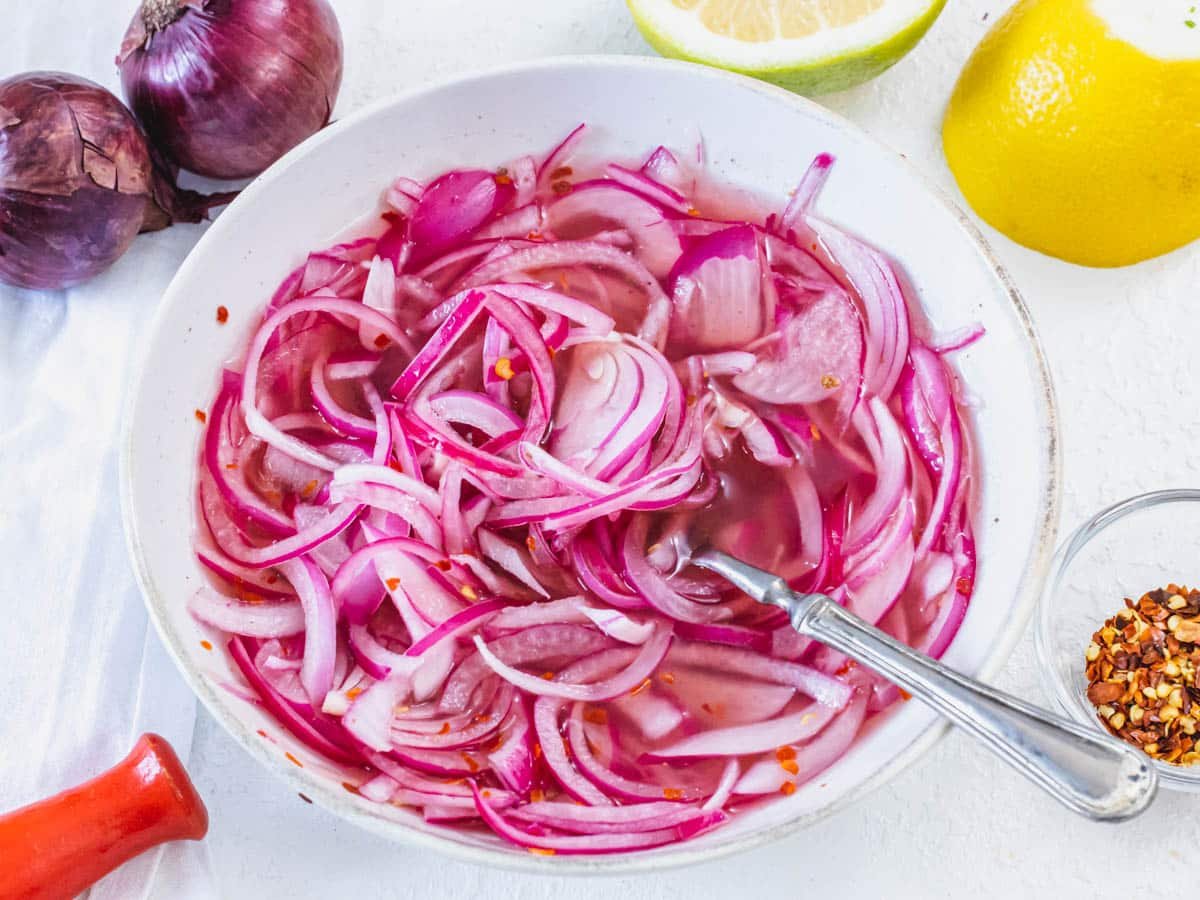 Pickled red onions with a fork