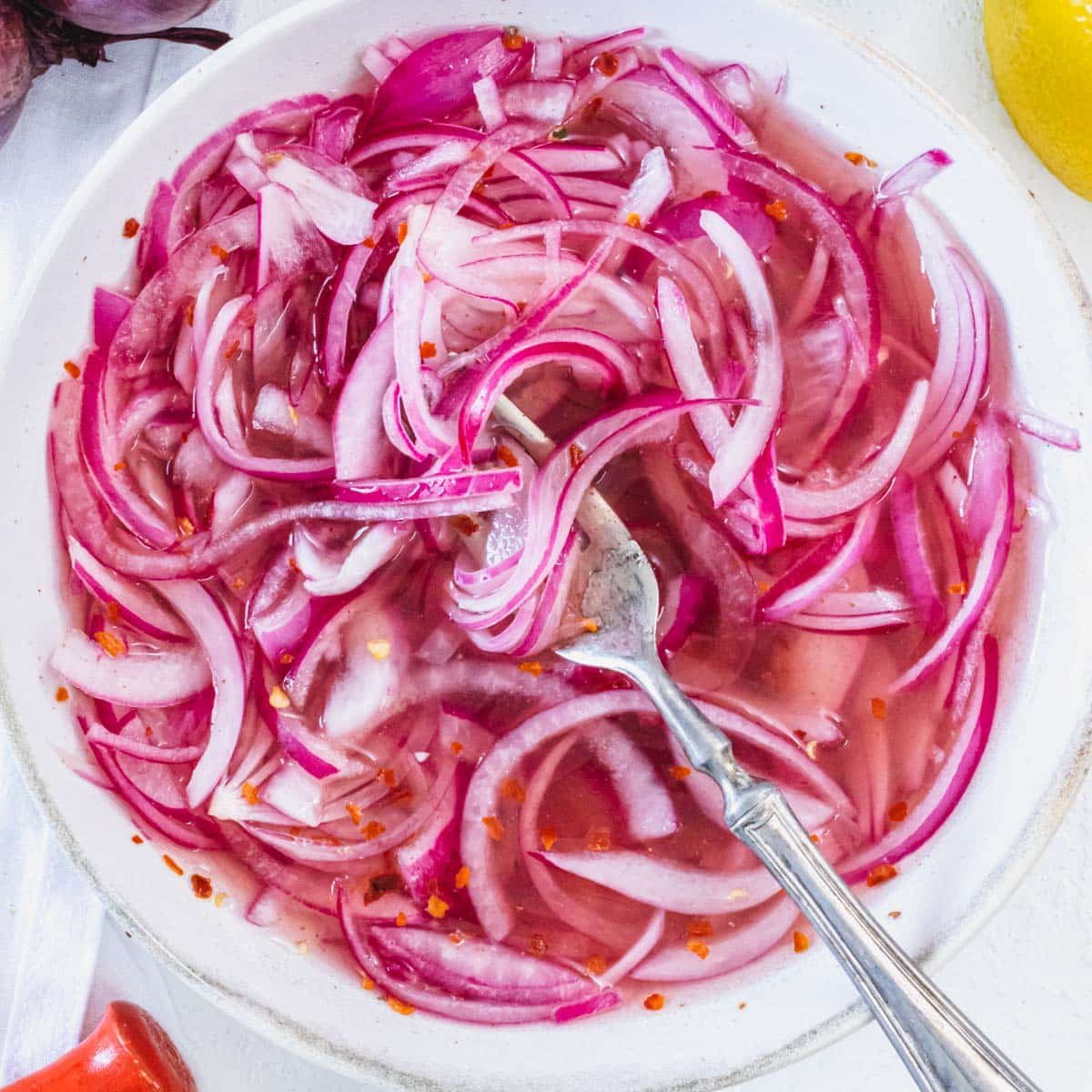 Pickled red onions in a white bowl