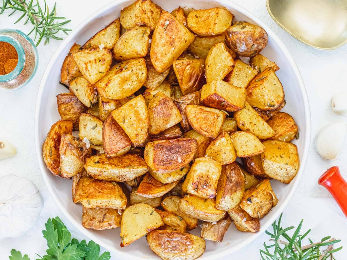 Roasted Potatoes in a white bowl with rosemary