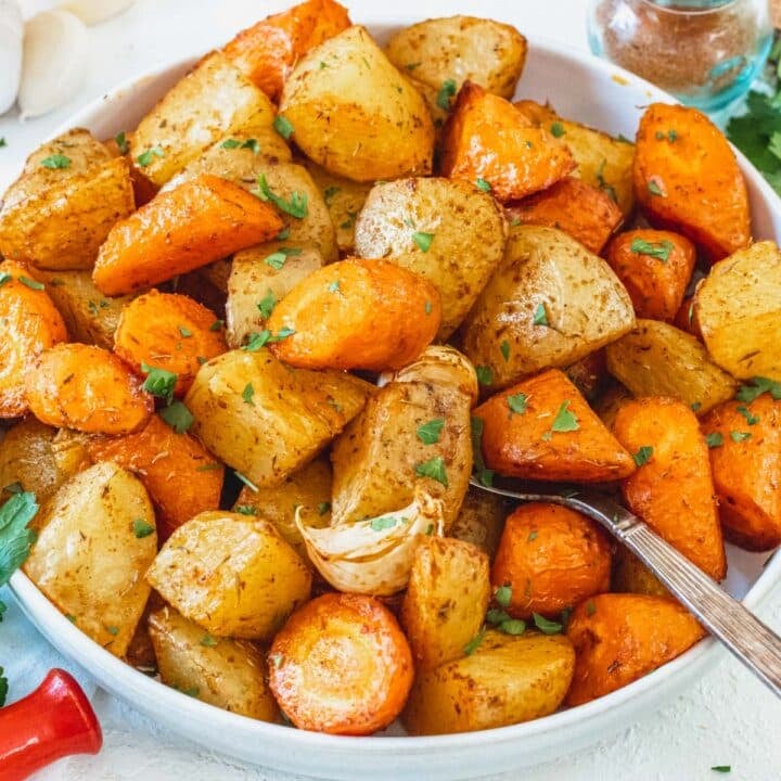 Roasted carrots and potatoes with parsley and a silver spoon