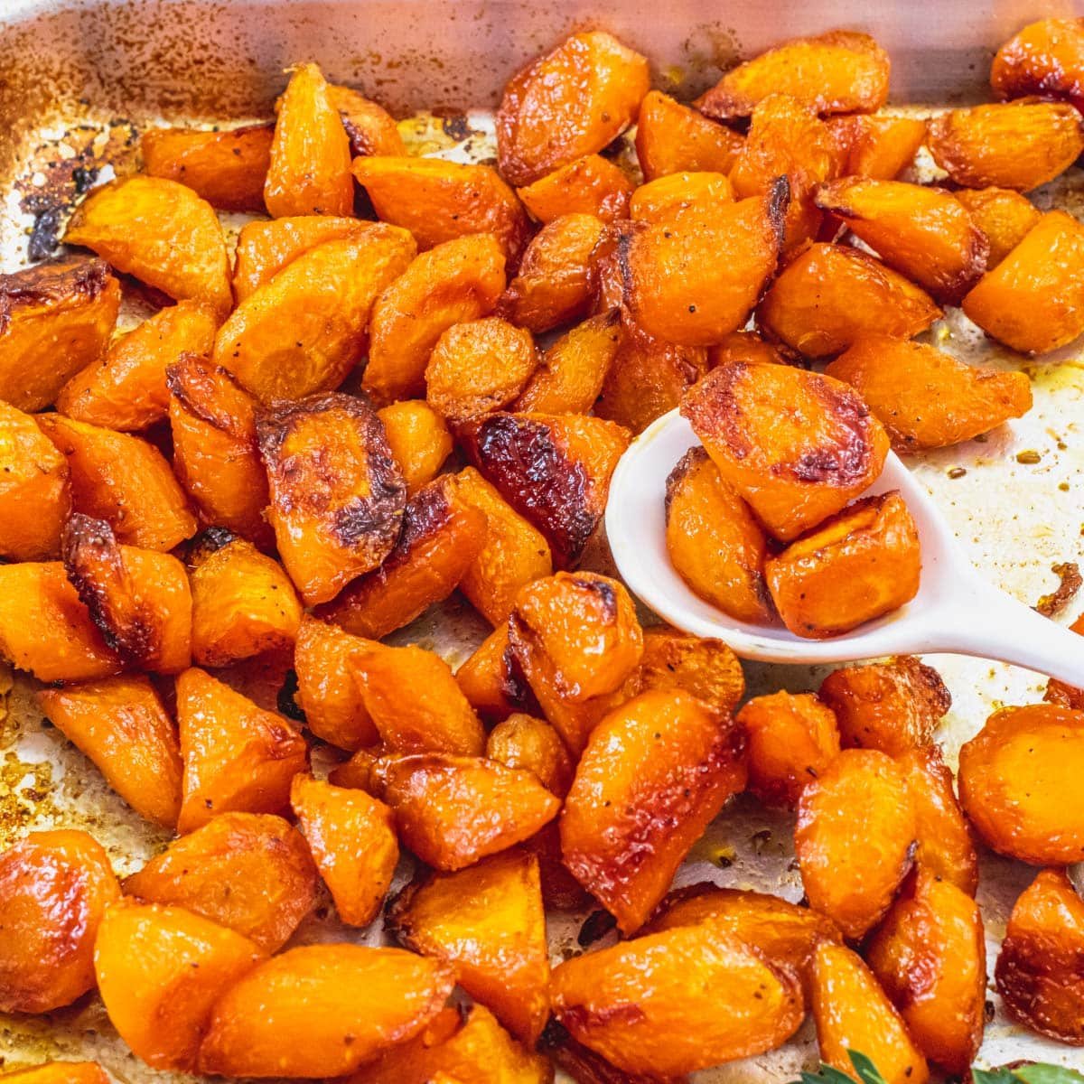 Roasted carrots with a white spoon