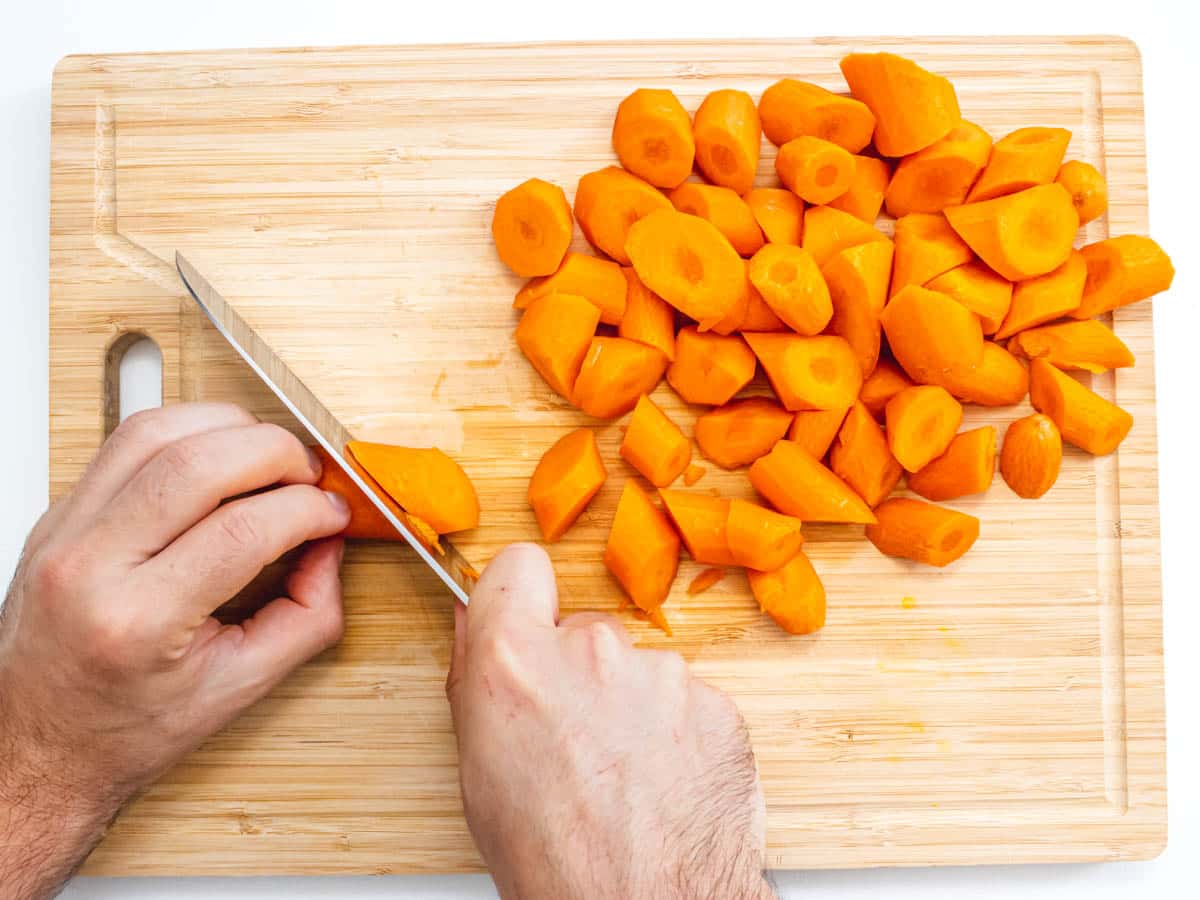 hands and knife slicing carrots