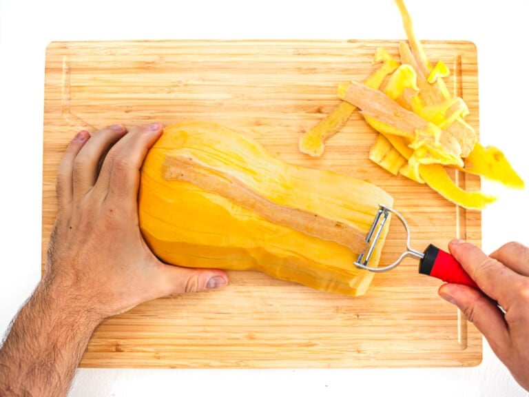 peeling the butternut squash with a vegetable peeler