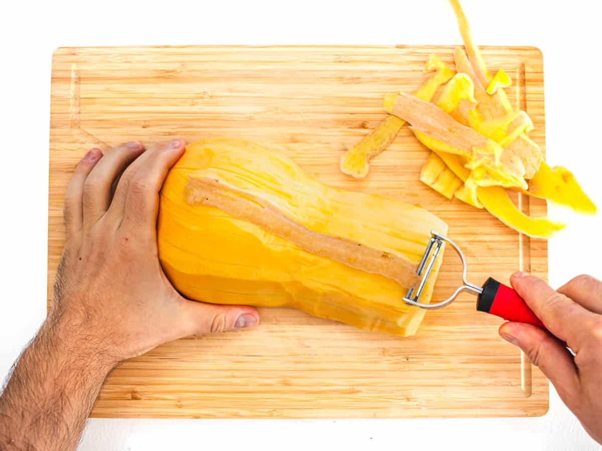 peeling the butternut squash with a vegetable peeler