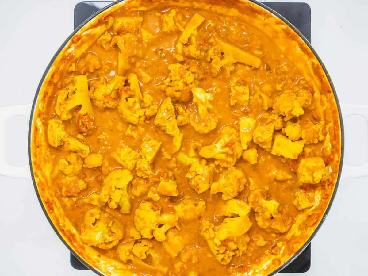 Tofu curry simmering in a skillet