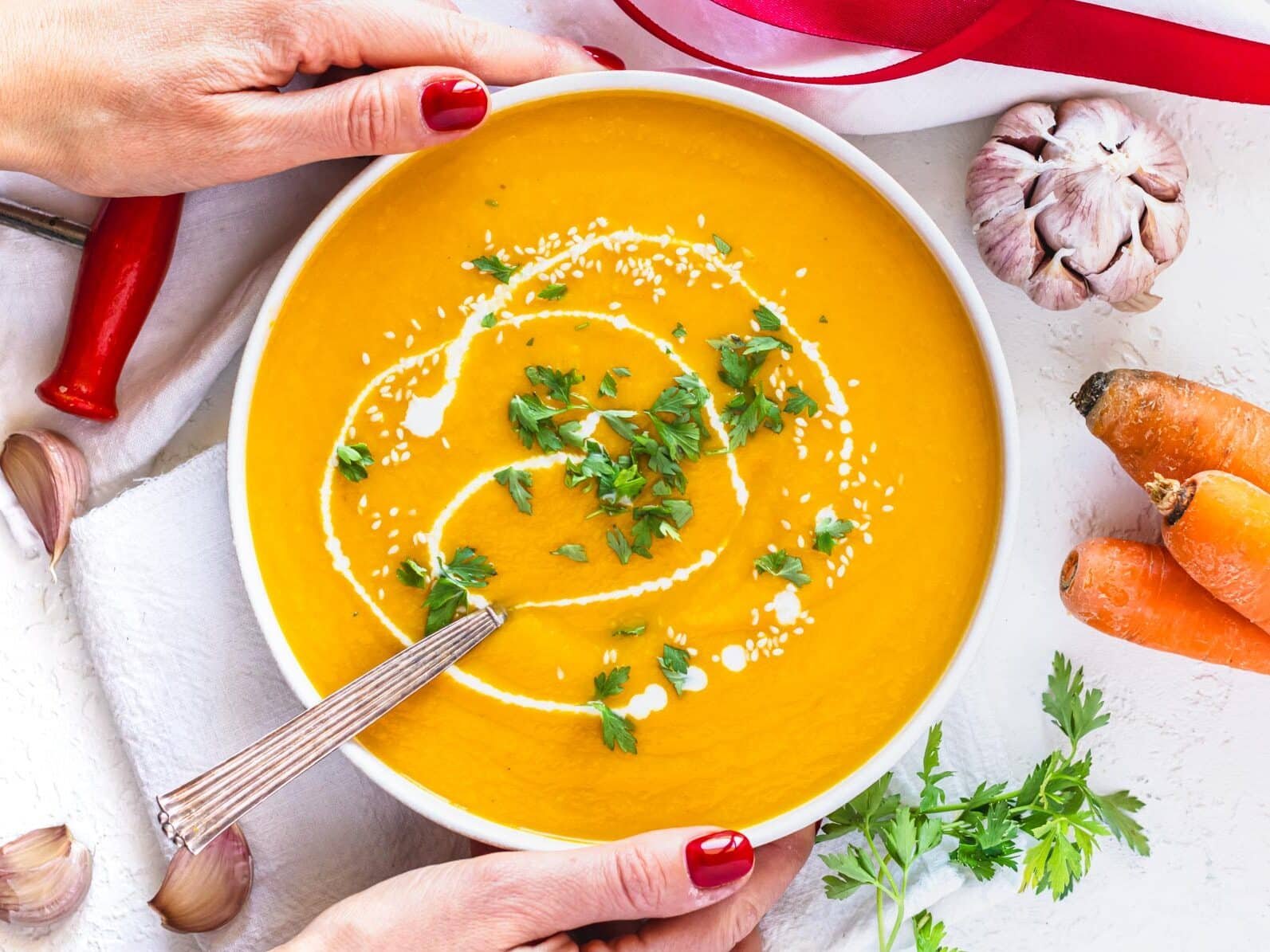 carrot soup in a bowl with hands