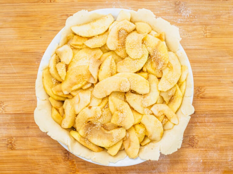 vegan pie crust with sliced apples in a pie plate