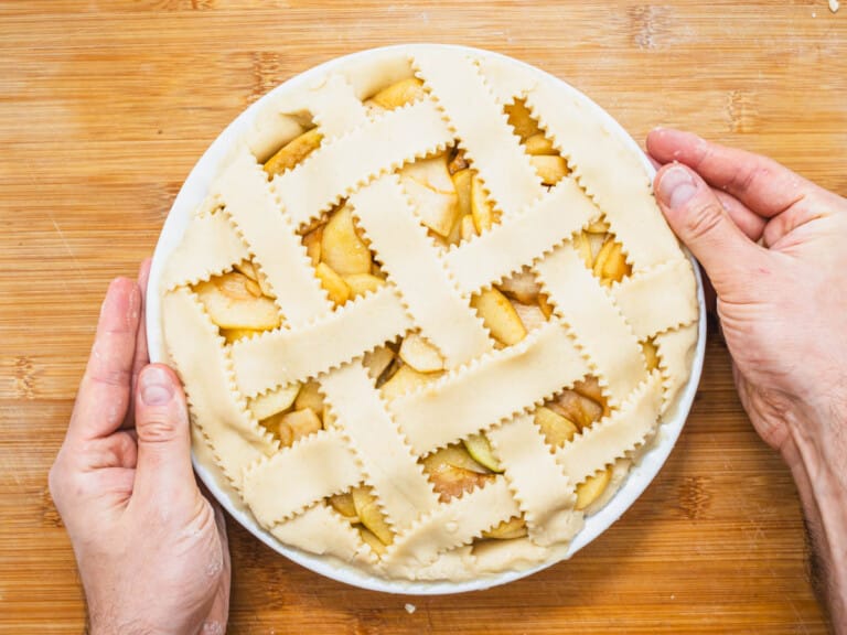 vegan apple pie with hands before baking