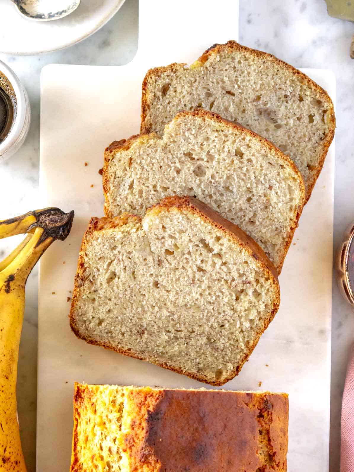 vegan banana bread with 3 slices cut on a cutting board