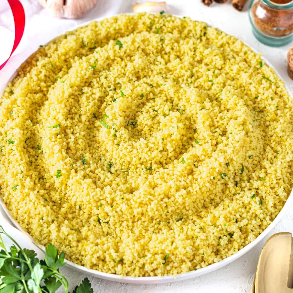 Yellow couscous with spices served on a white plate