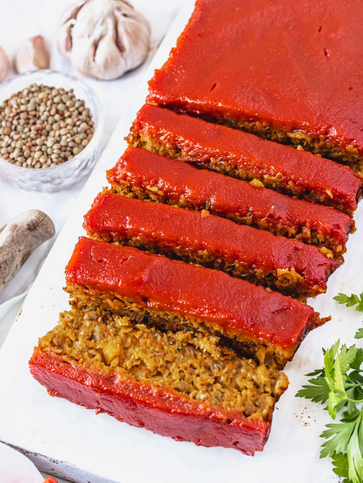 Lentil loaf with ketchup sauce on a white cutting board
