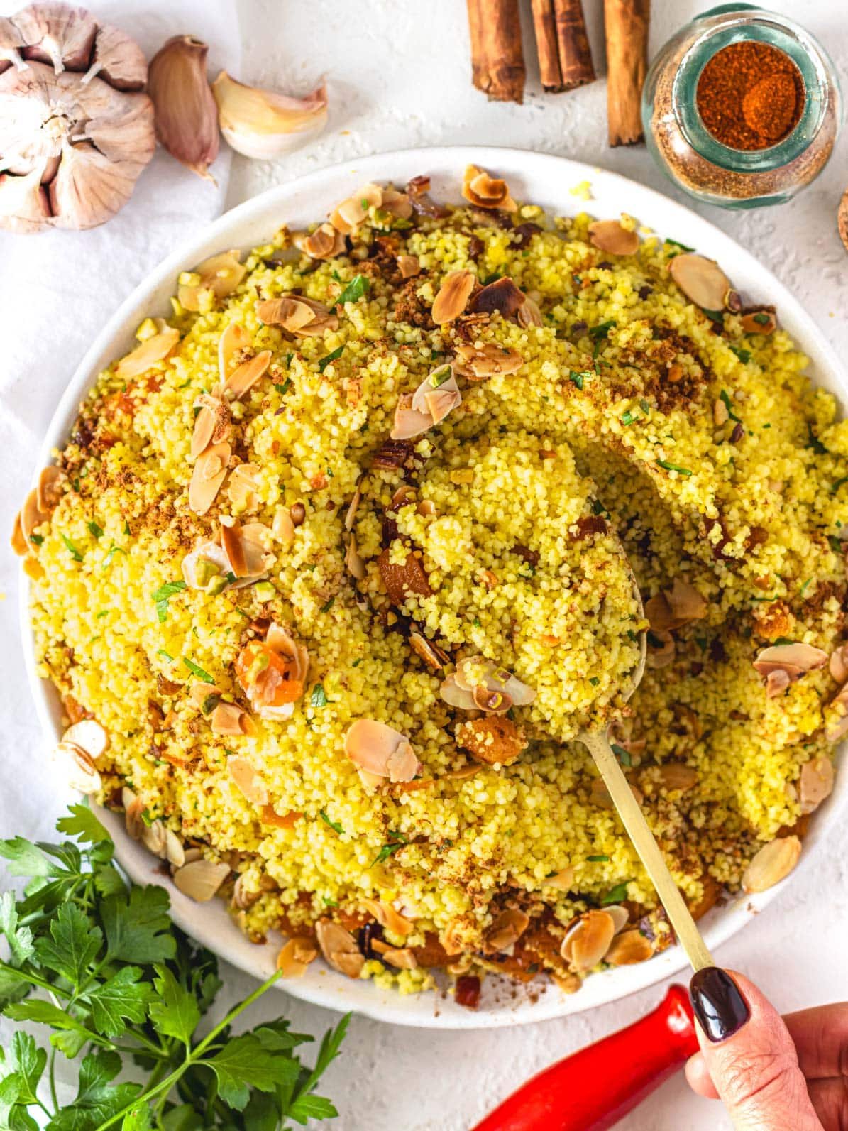 Moroccan couscous with hand and a golden spoon