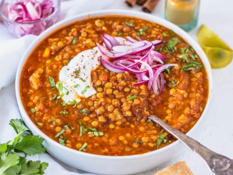 Moroccan lentil soup with a silver spoon and pickled red onions