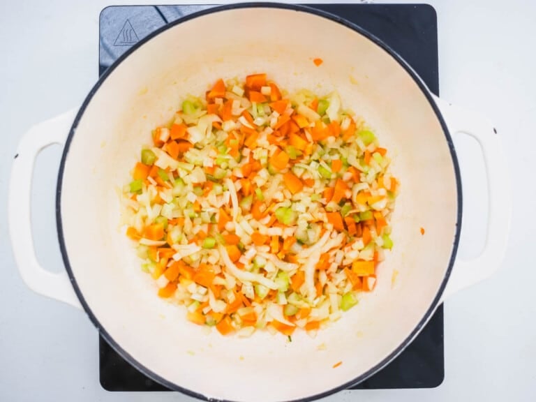 white skillet with chopped carrot, celery and onion