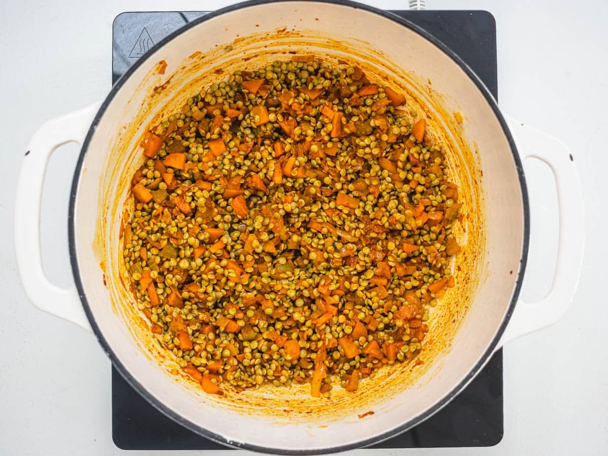 lentils, vegetables and spices in a white skillet