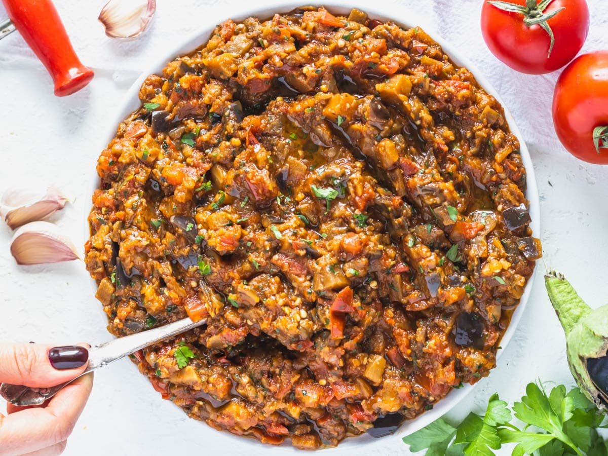 Zaalouk on a plate with tomatoes and parsley on the side