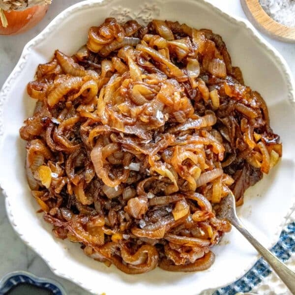 caramelized onions in a white bowl with a fork