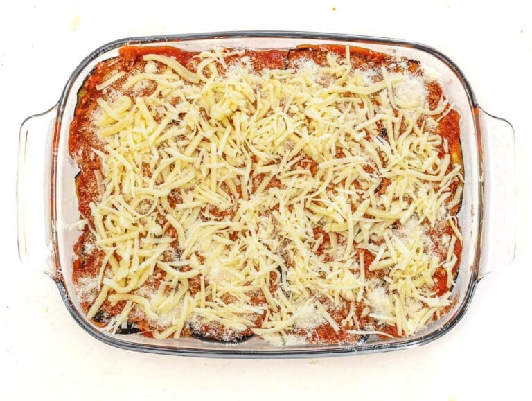 sprinkled mozzarella cheese on tomato sauce and eggplant