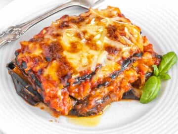 eggplant parmigiana on a white plate with a silver fork