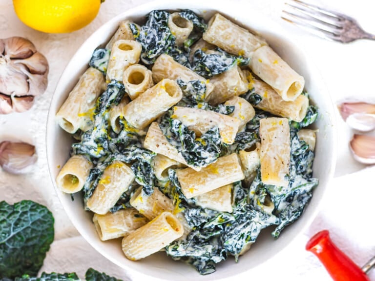 kale pasta in a bowl with a fork on the side