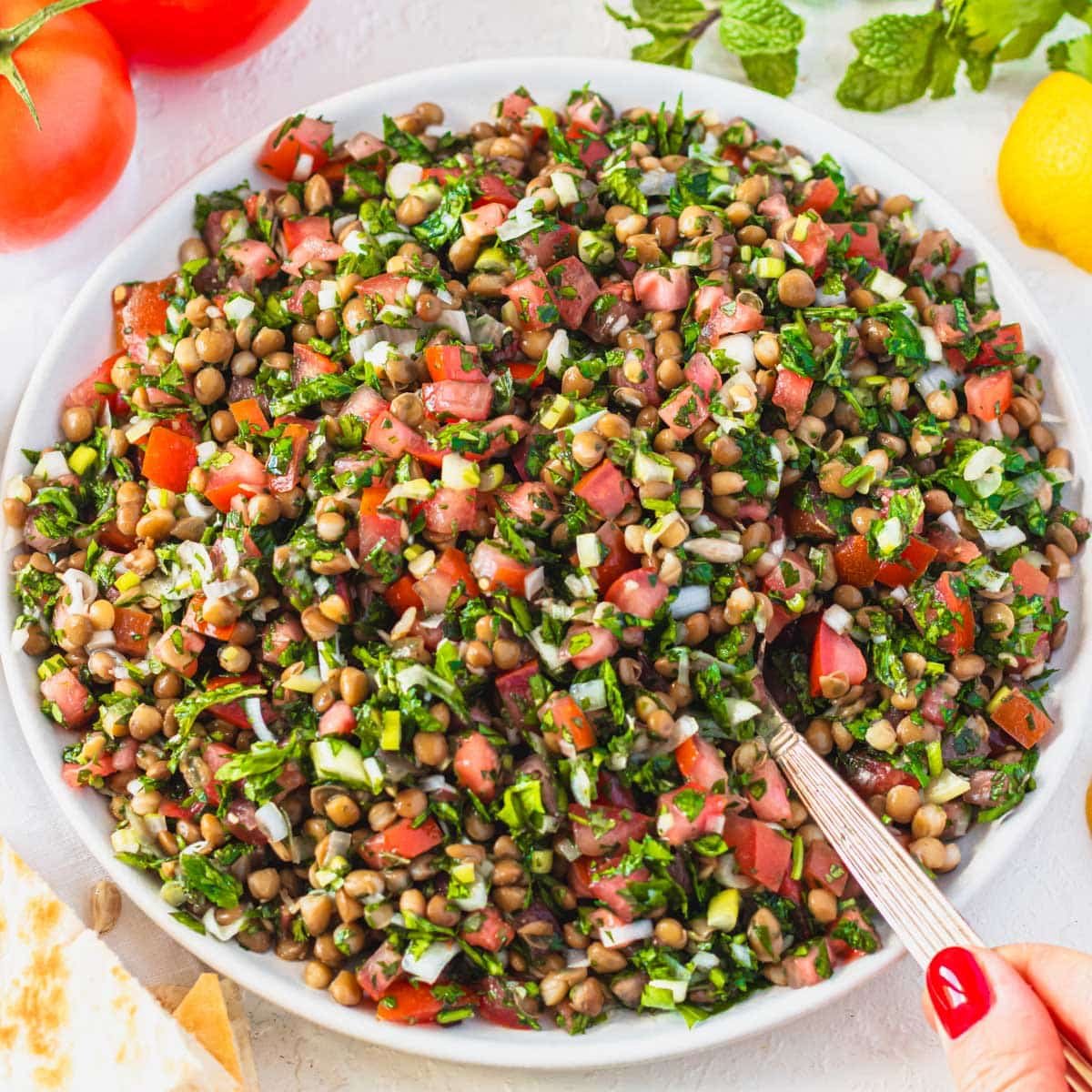lentil tabbouleh with silver spoon and hand