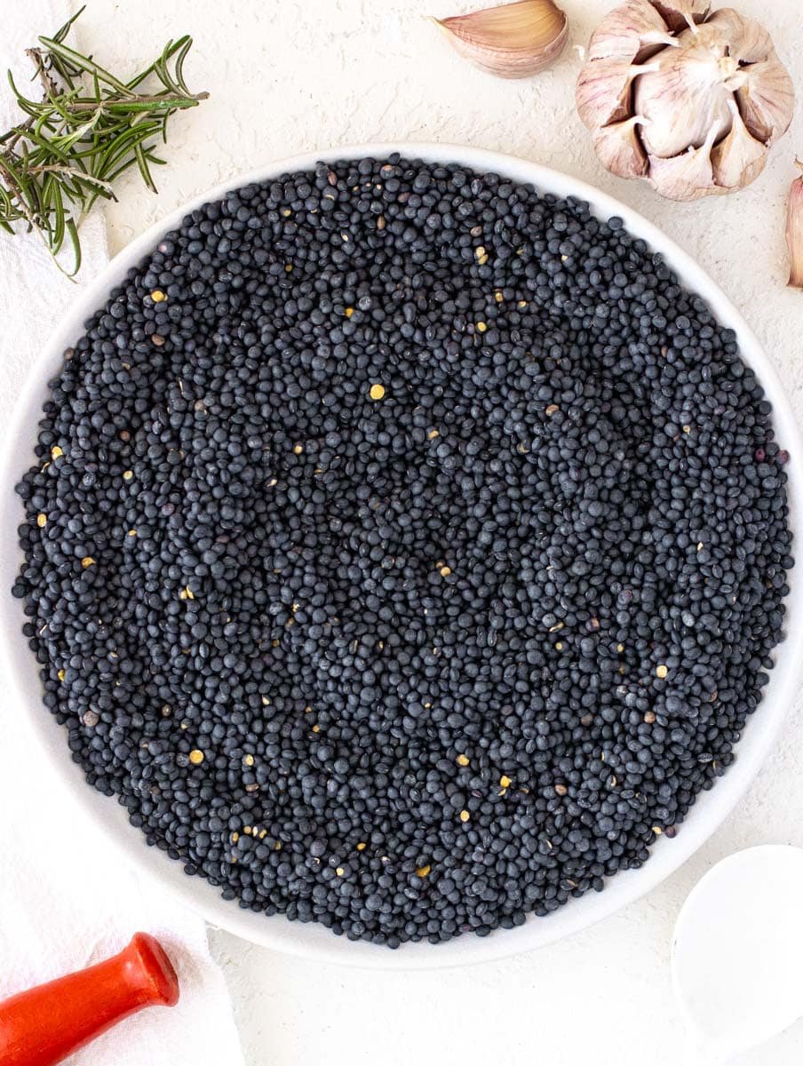dry black lentils raw on a plate