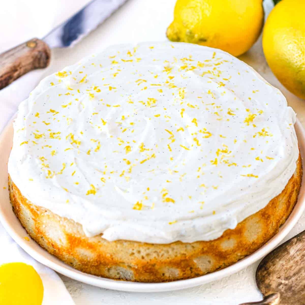 vegan lemon cake with frosting and grated lemon zest