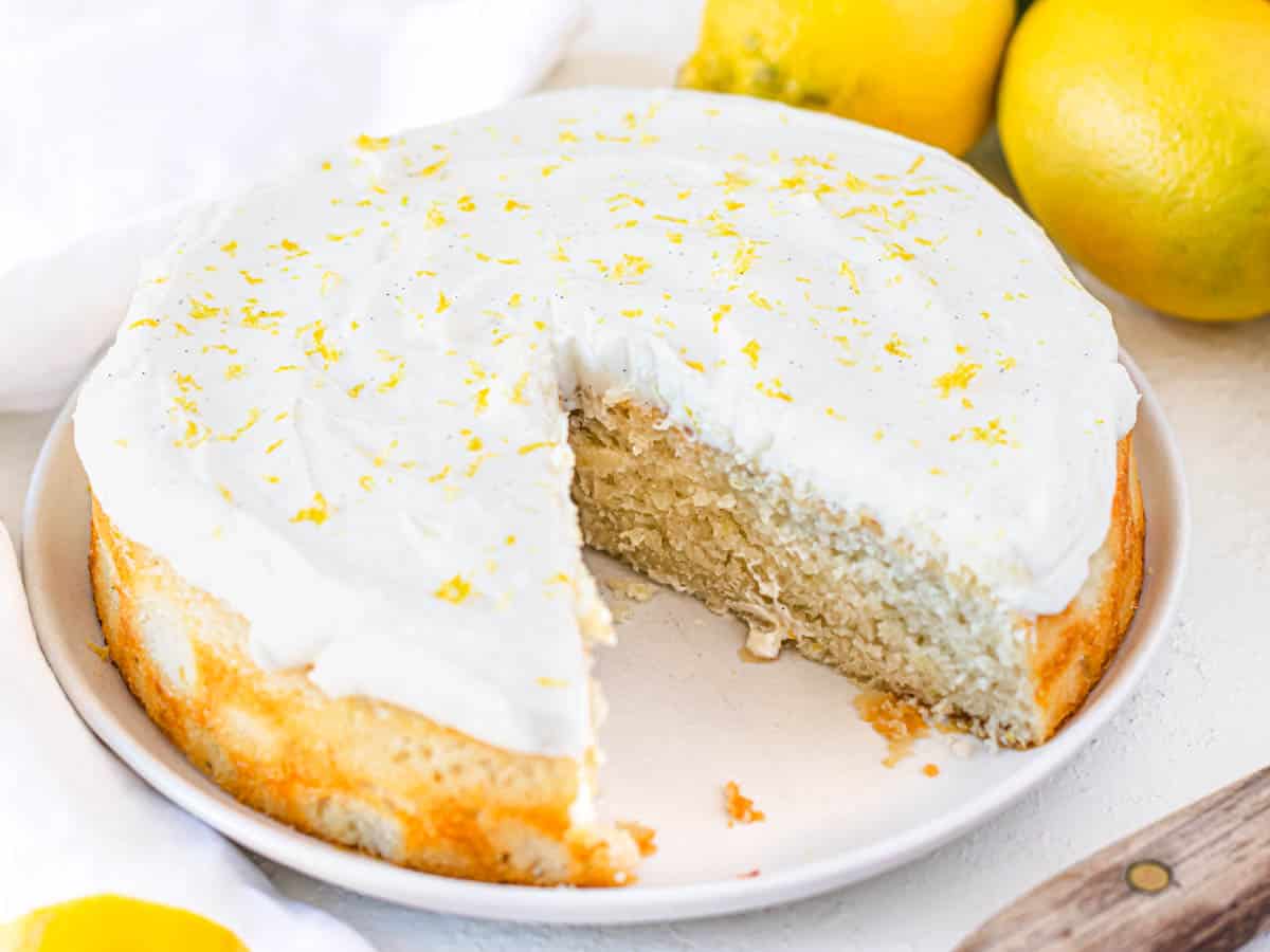 vegan lemon cake with lemon zest and a missing slice