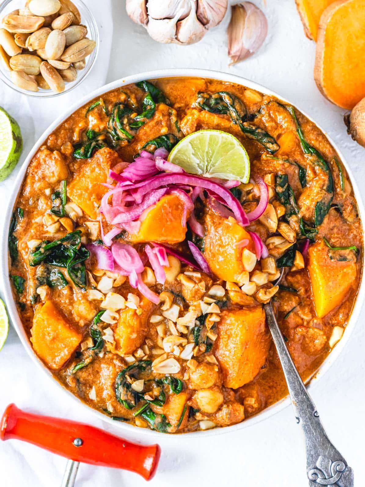 African peanut stew in a bowl with silver spoon and a lime wedge
